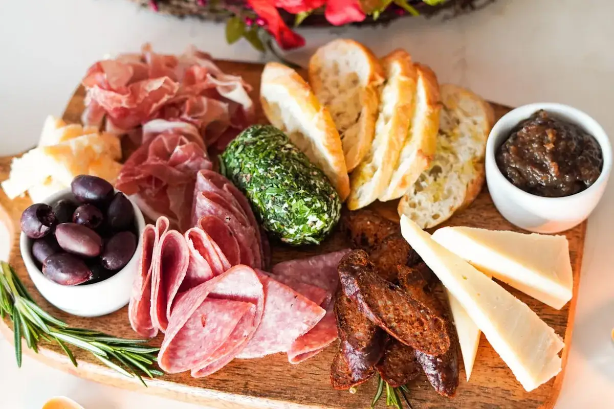 Deska serów i wędlin: kiełbasa dojrzewająca jak jeść, oliwki, pieczywo, ser, pasta figowa. Idealna na przekąskę.