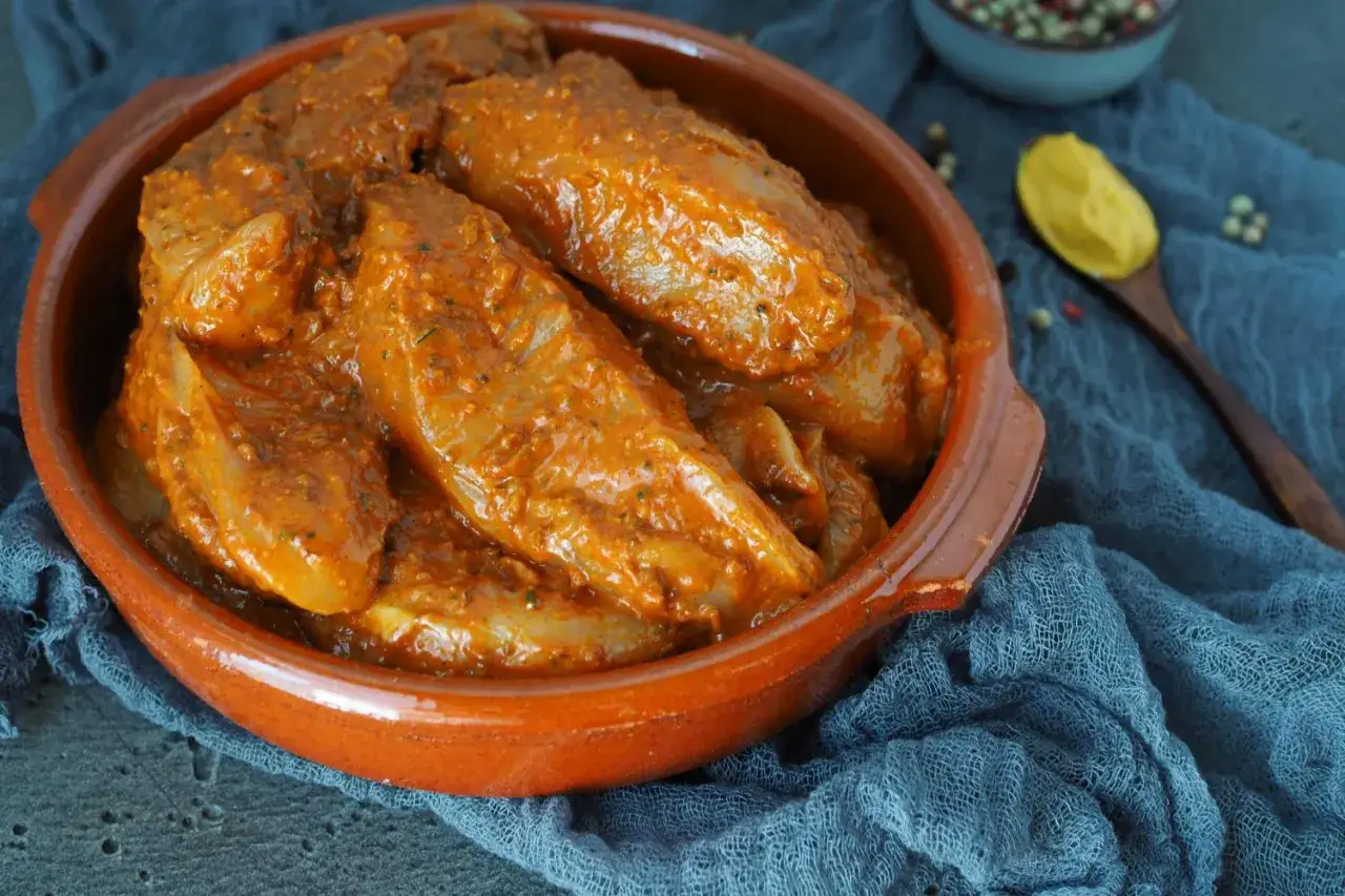 Fleisch marinieren für den Grill. Saftige Hähnchenbrust in einer würzigen Marinade, bereit für den Grill.
