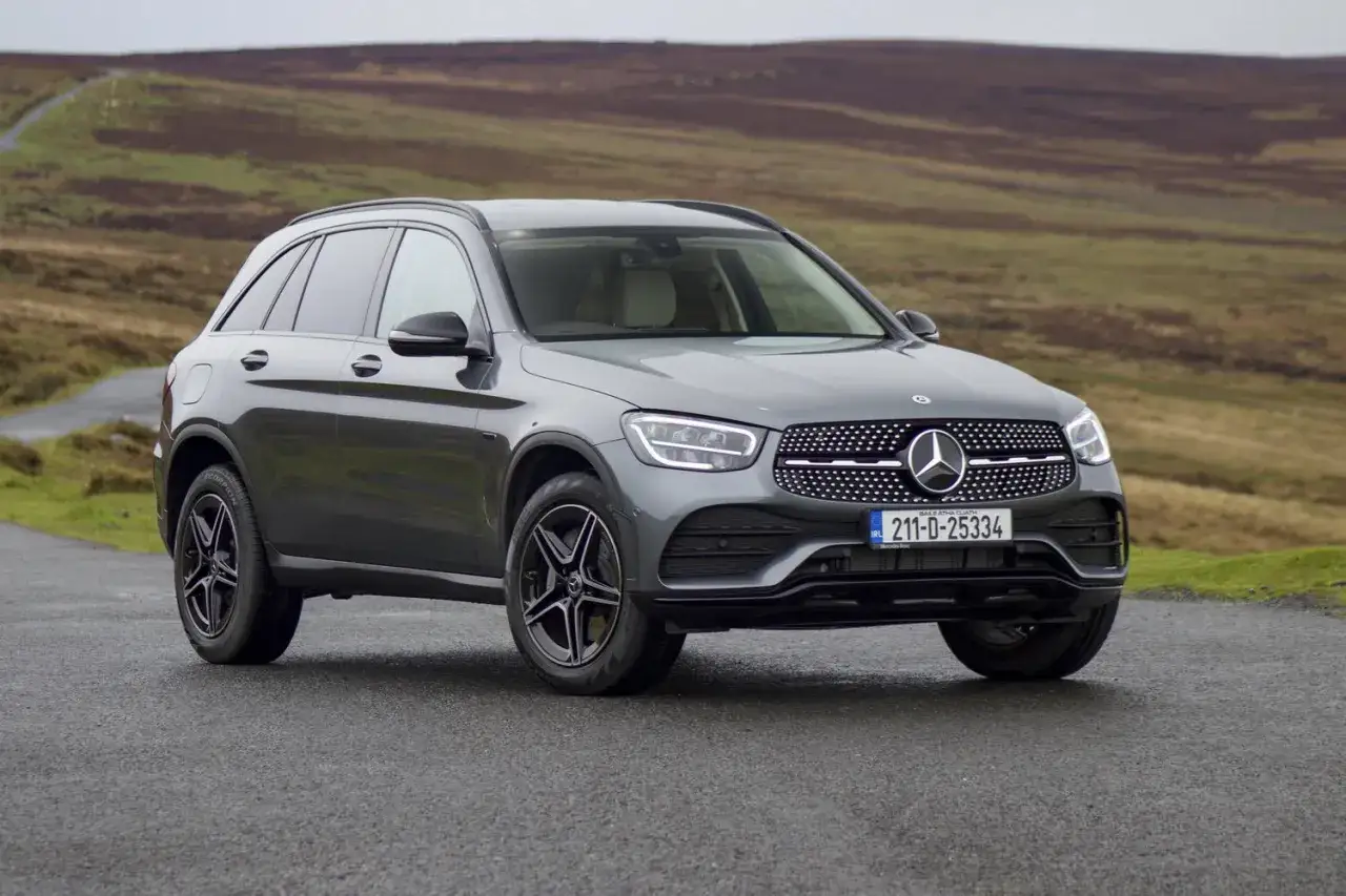 Gr&aring; Mercedes GLC 300 de hybrid p&aring; en grusv&auml;g i kuperad terr&auml;ng. En perfekt bil f&ouml;r en testk&ouml;rning i det fria.