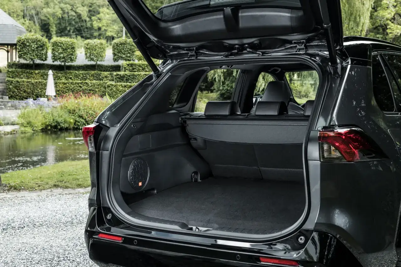 Bagażnik czarnego **Toyota RAV4 2020** z otwartą klapą. Widać subwoofer JBL.
