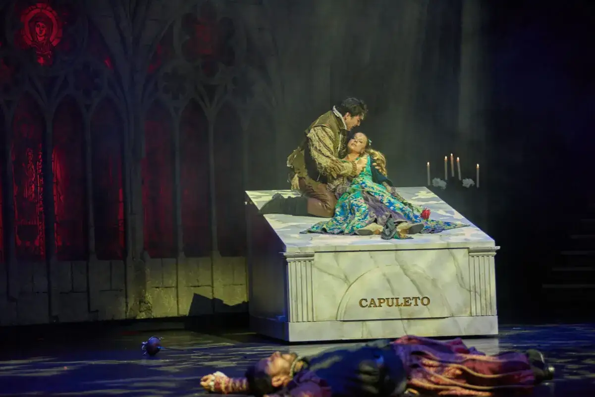 Romeo y Julieta resumen corto: Romeo abraza a Julieta en su tumba, mientras él yace muerto a sus pies.