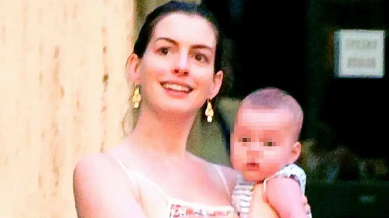 Anne Hathaway z dziećmi, uśmiechnięta mama trzyma na rękach swoje pociechy.