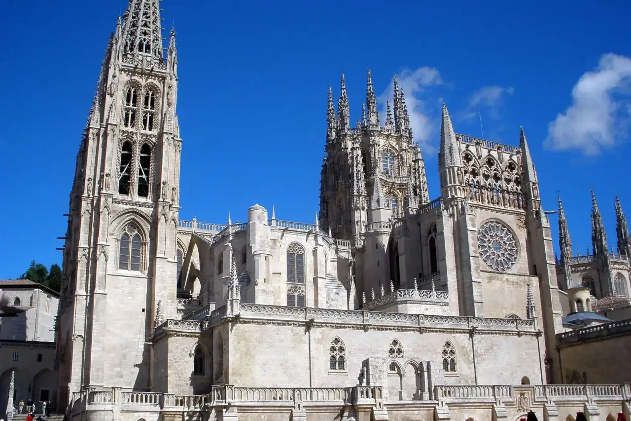 Die beeindruckende Burgos Kathedrale ragt mit ihren filigranen T&uuml;rmen und Spitzd&auml;chern in den blauen Himmel.