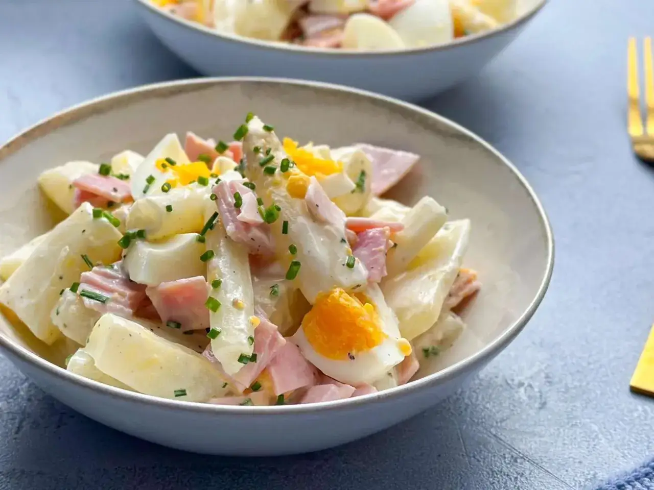 Leckerer Spargelsalat mit Kartoffeln, Ei und Schinken, wie ihn Oma macht. Mit frischem Schnittlauch bestreut.