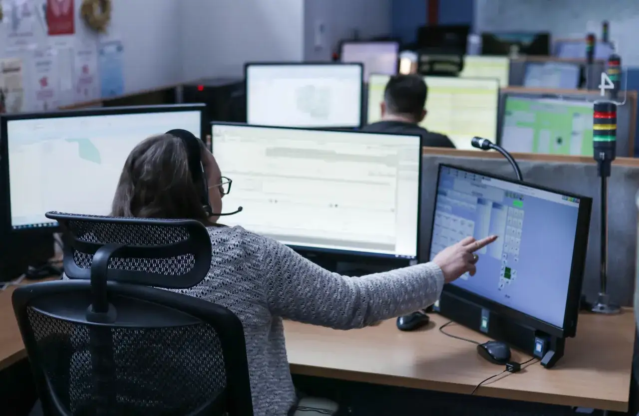 Operator 112 pracuje przy komputerze, obsługując zgłoszenia. Zarobki operatora 112 są zmienne.