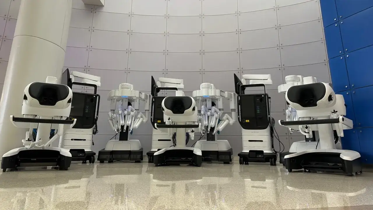 Rząd robotów chirurgicznych Intuitive, gotowych do pracy.
