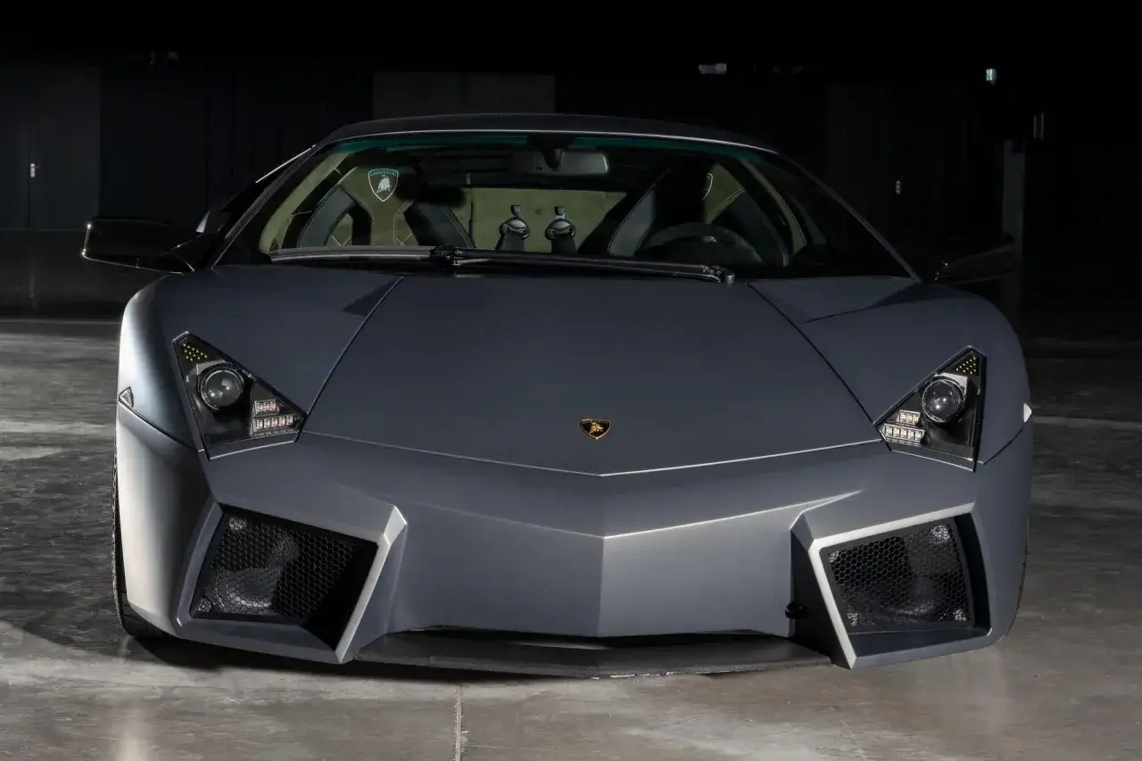 Szary Lamborghini Reventon z agresywnym przodem i charakterystycznym logo marki.