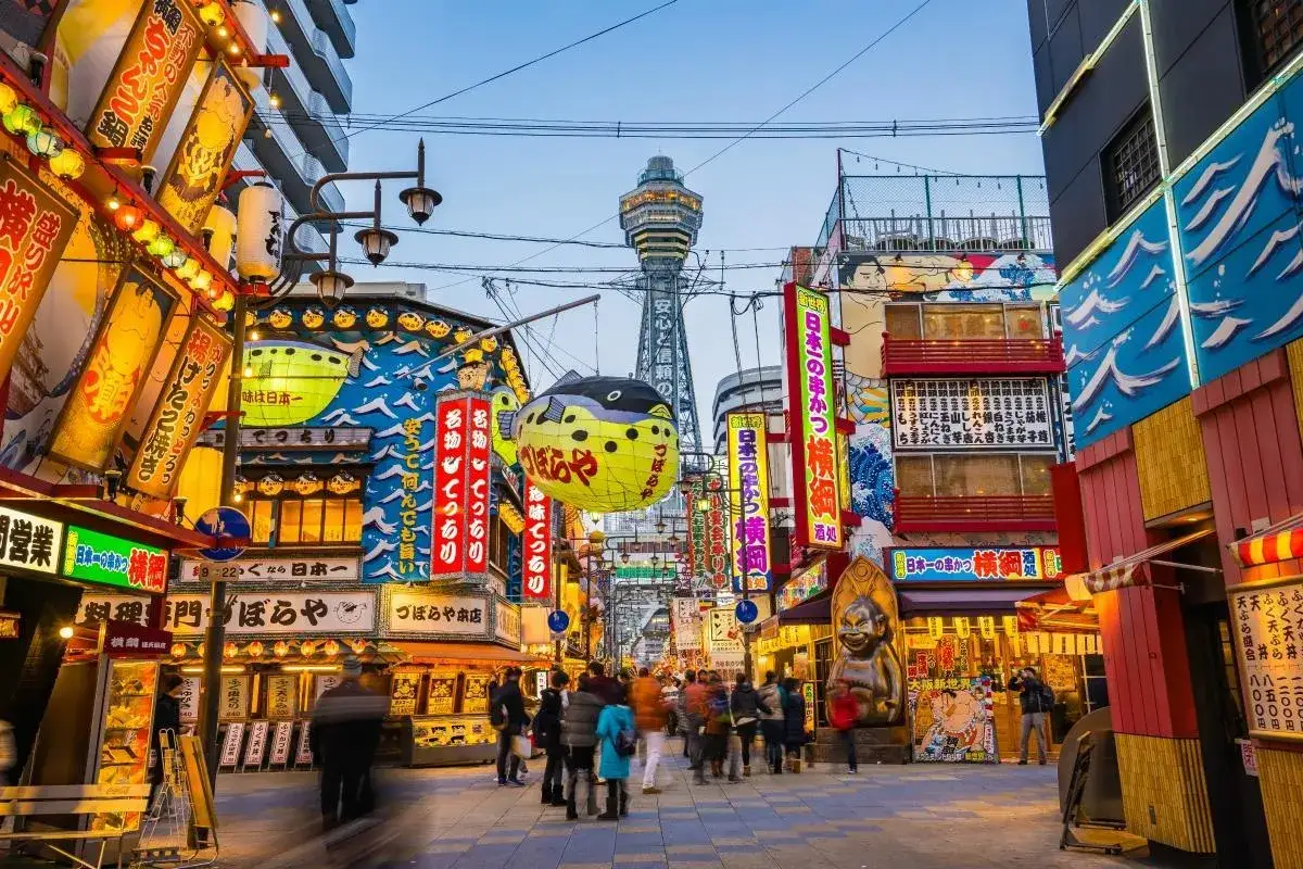 Kolorowa ulica w Japonii, pełna neonów i lampionów. W tle wieża Tsutenkaku. Idealne miejsce na niezapomnianą Japonia wycieczka.
