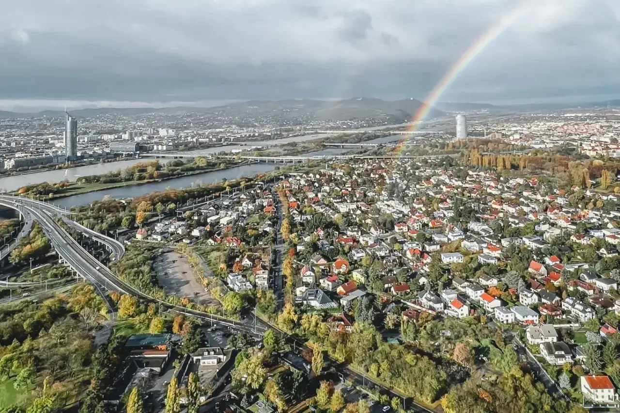 Vacker regnb&aring;ge &ouml;ver Wiens tak&aring;sar och Donau. En vy v&auml;rd att se i Wien, med moderna skyskrapor och charmiga villakvarter.