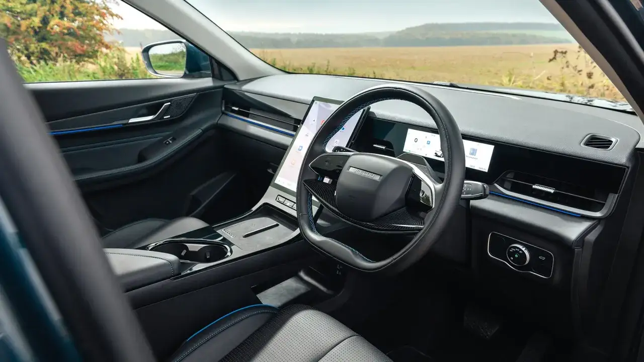 Interior del Jaecoo 5: volante moderno, pantalla t&aacute;ctil vertical y asientos de cuero negro con costuras azules.