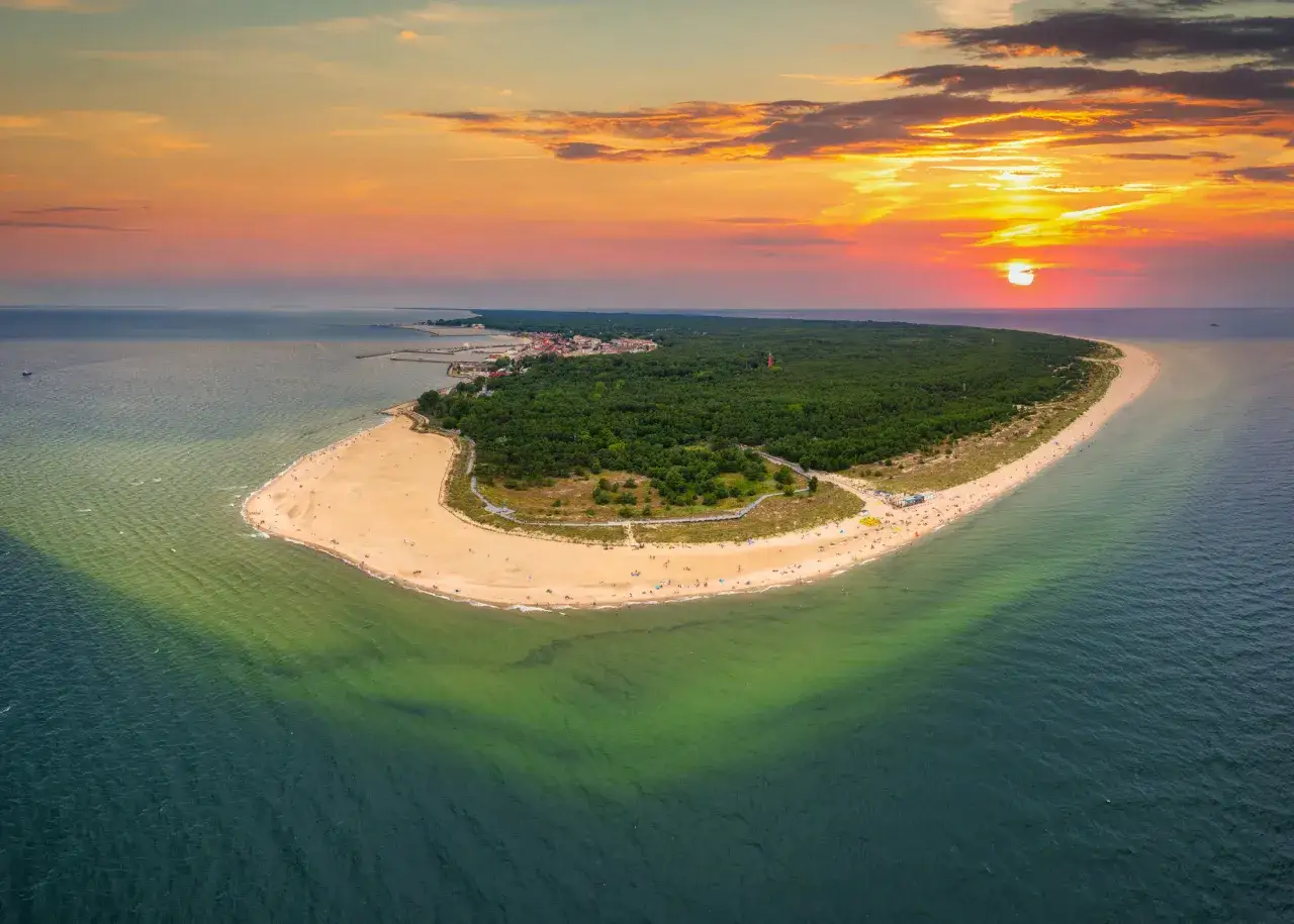 Zachód słońca nad Półwyspem Helskim. Piękna plaża, las i morze w odcieniach zieleni i błękitu.