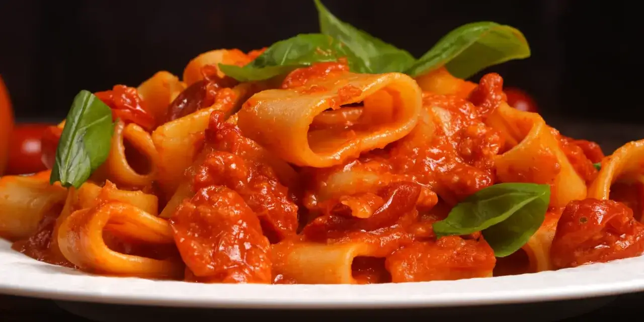 Rigatoni allo scarpariello, un piatto di pasta ricco e saporito, condito con pomodoro fresco, basilico e un tocco piccante.