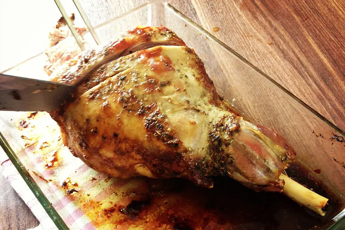 Un gigot d'agneau r&ocirc;ti, pr&ecirc;t &agrave; &ecirc;tre d&eacute;coup&eacute;, parfait pour une recette agneau pascal.