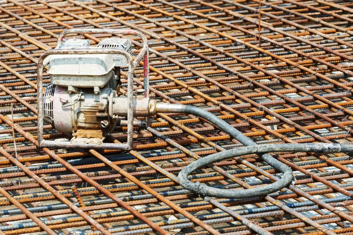 Máquina de vibración para la puesta en obra del hormigón, lista sobre la malla de acero de una construcción.