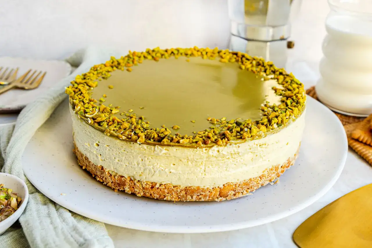 Ein cremiger Pistazien Cheesecake mit knackigem Boden und gehackten Pistazien verziert. Perfekt für Genießer!