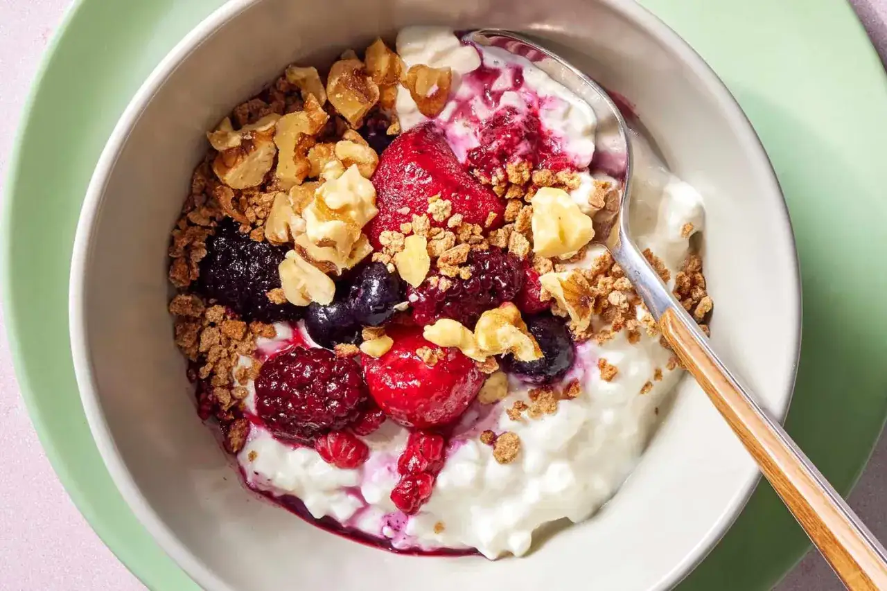 Un bol de fromage blanc 3 matière grasse régime garni de fruits rouges, noix et granola. Un petit-déjeuner sain et gourmand.