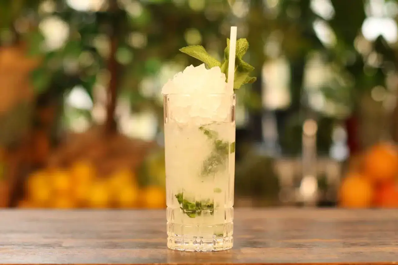 Orzeźwiający mojito w szklance z lodem i miętą, gotowy do wypicia w letni dzień.