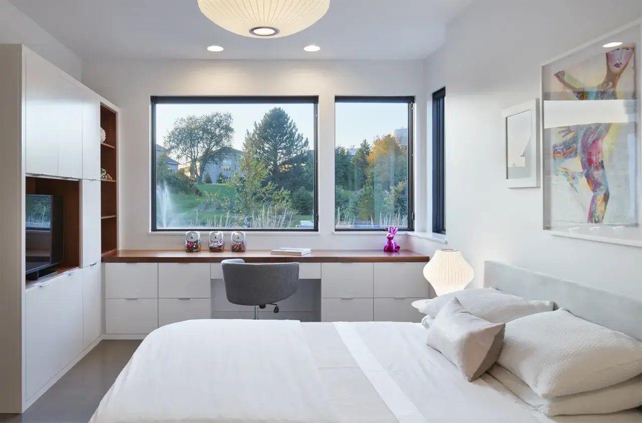 Moderna camera da letto con scrivania integrata, perfetta per idee scrivania camera da letto. Ampia finestra con vista sul verde.