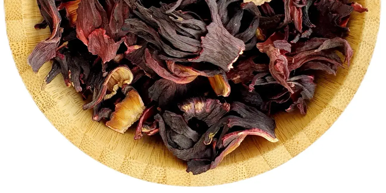Suszone płatki hibiskusa w drewnianej miseczce, gotowe do zaparzenia orzeźwiającego naparu z hibiskusa.