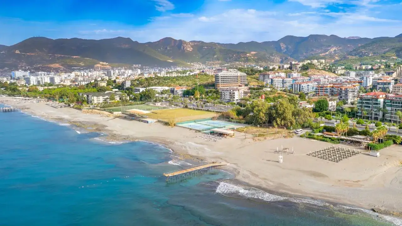 Widok na plażę z molo, kortami tenisowymi i hotelem w tle. Wiele pozytywnych michell hotel spa opinie potwierdza urok tego miejsca.