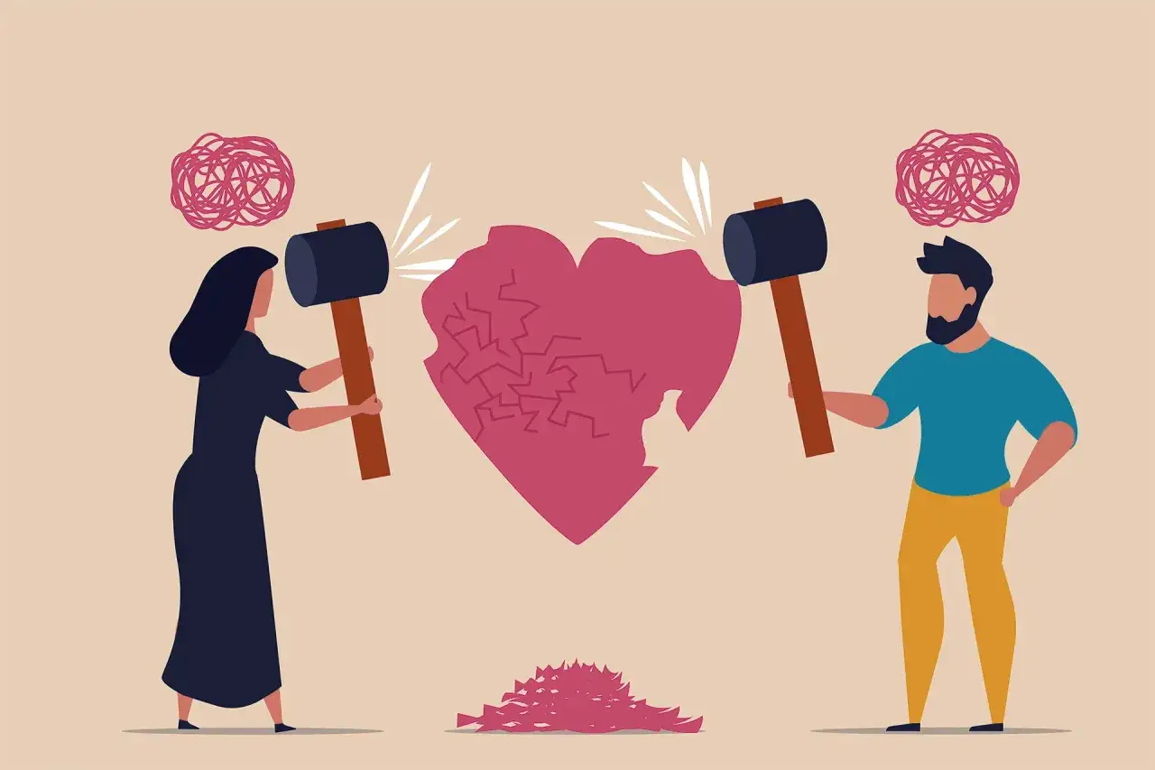 Una pareja rompe un coraz&oacute;n con martillos. Un s&iacute;mbolo de c&oacute;mo sacar a tu hija de una relaci&oacute;n t&oacute;xica.