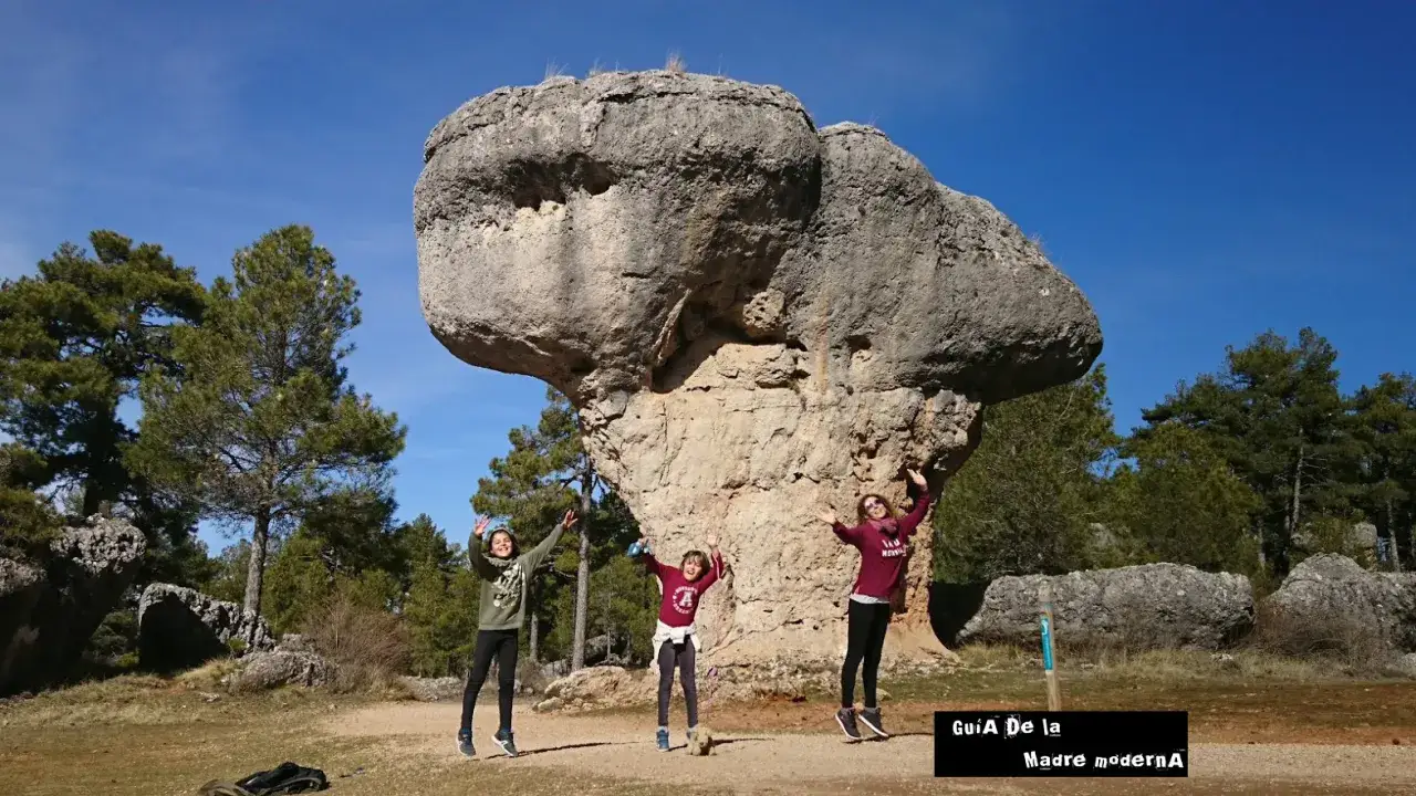Tres ni&ntilde;os saltan de alegr&iacute;a frente a una roca gigante en Cuenca. &iexcl;Un plan genial que ver en Cuenca con ni&ntilde;os!
