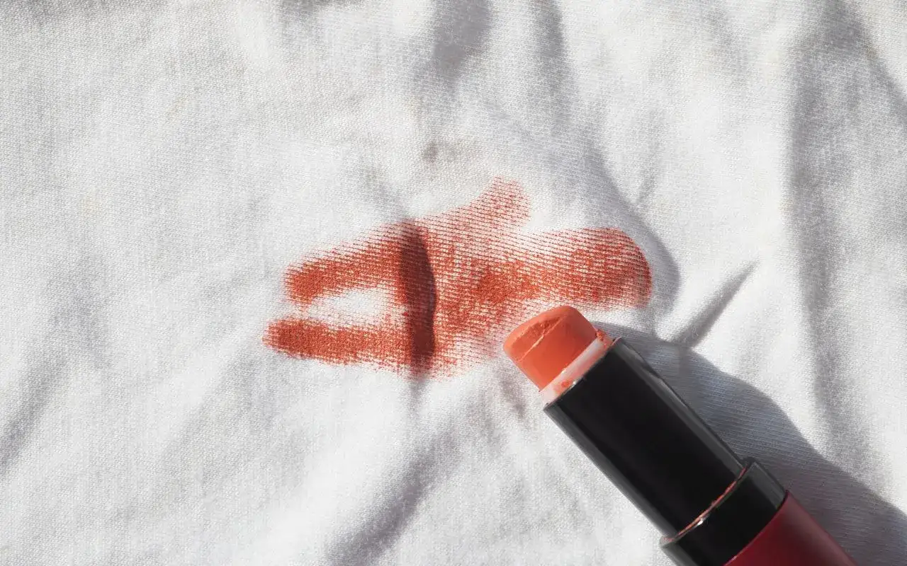 Rouge à lèvres orange sur tissu blanc, un défi pour enlever tache rouge à lèvre sur polyester.