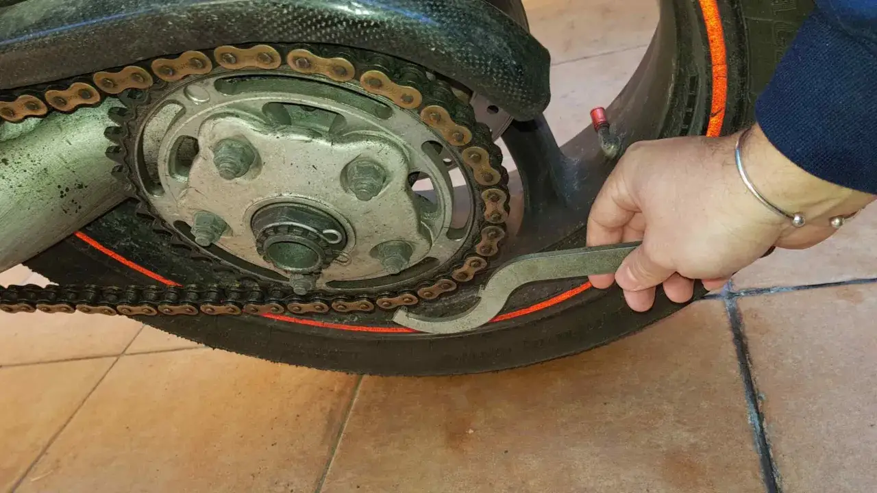 Regolazione della tensione catena moto con apposito attrezzo.