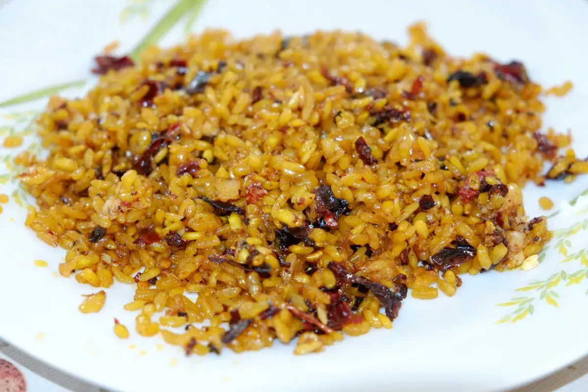 Arroz a banda, uno de los platos más representativos de las cosas típicas de Alicante, servido en un plato blanco con un borde floral.