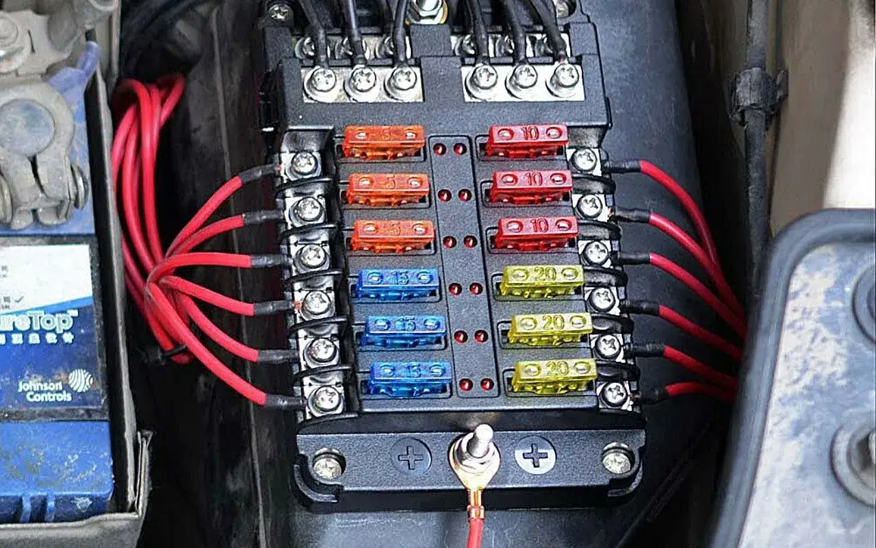 Caja de fusibles con cables rojos conectados. Pregúntate qué pasa si pongo un fusible de mayor amperaje.