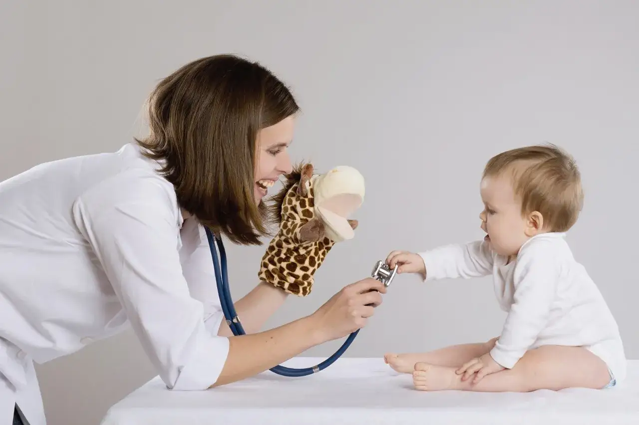 Bambina con pupazzo giraffa e stetoscopio, gioco che simula una visita medica. Un soffio al cuore cos'&egrave;?