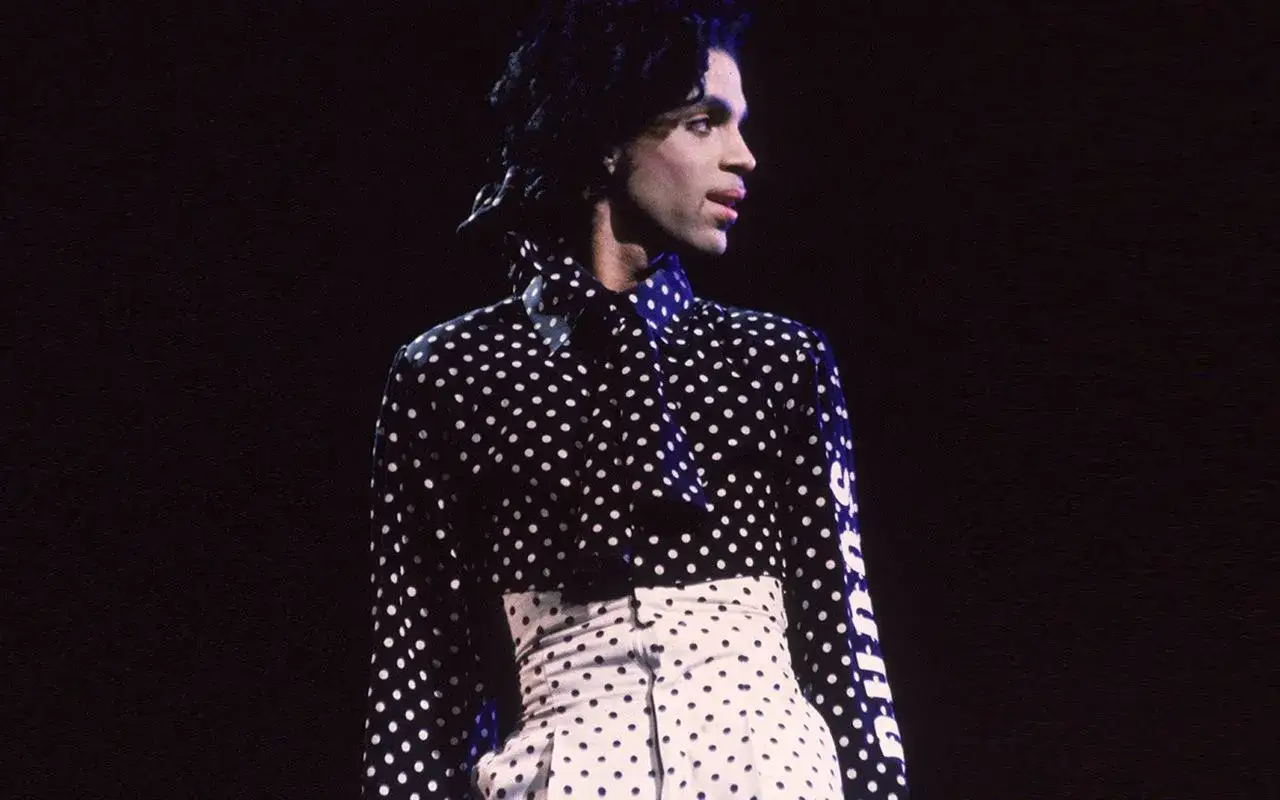 Iconico Prince con camicia a pois uomo e pantaloni a vita alta, un look indimenticabile.