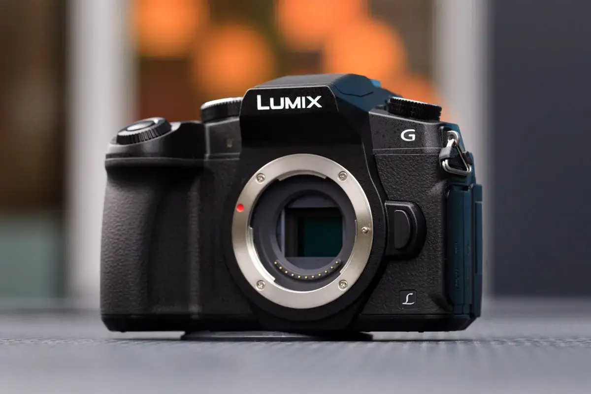 Czarny aparat Lumix G z widocznym mocowaniem obiektywu. Migawka elektroniczna gotowa do uchwycenia chwili.