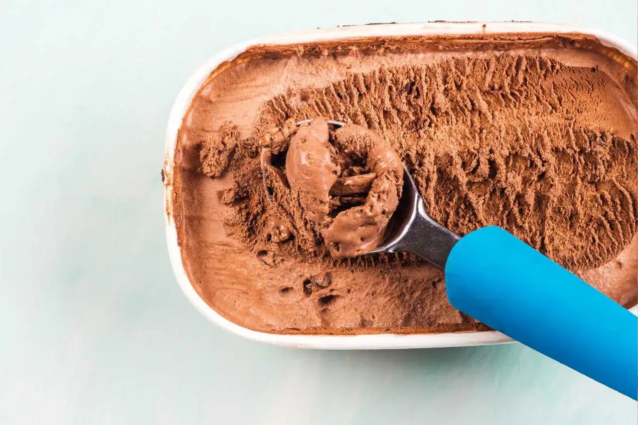 Un cucchiaio raccoglie un gelato al cioccolato leggermente scongelato. Non preoccuparti, il gelato scongelato si pu&ograve; ricongelare per gustarlo ancora!