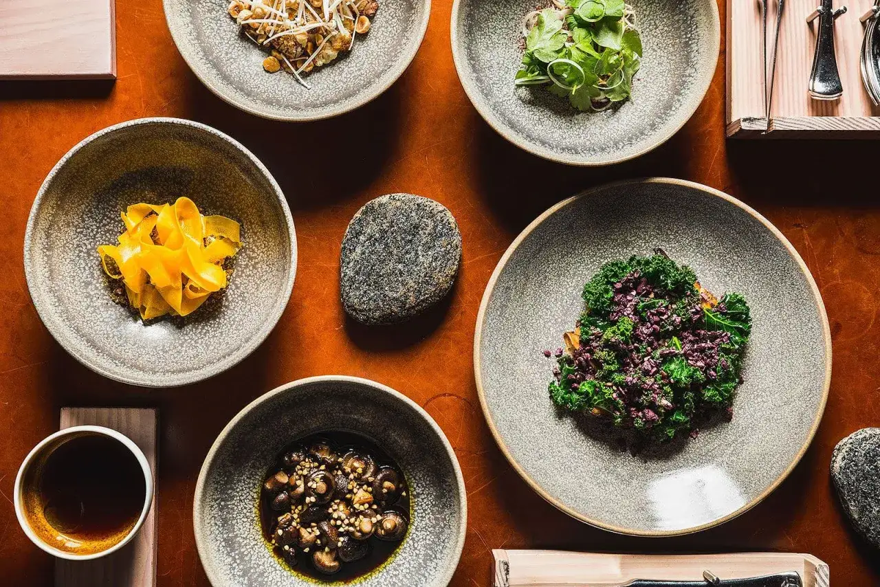 Vackra rätter på en rustik duk, en kulinarisk upplevelse som för tankarna till en Michelin restaurang Sverige.