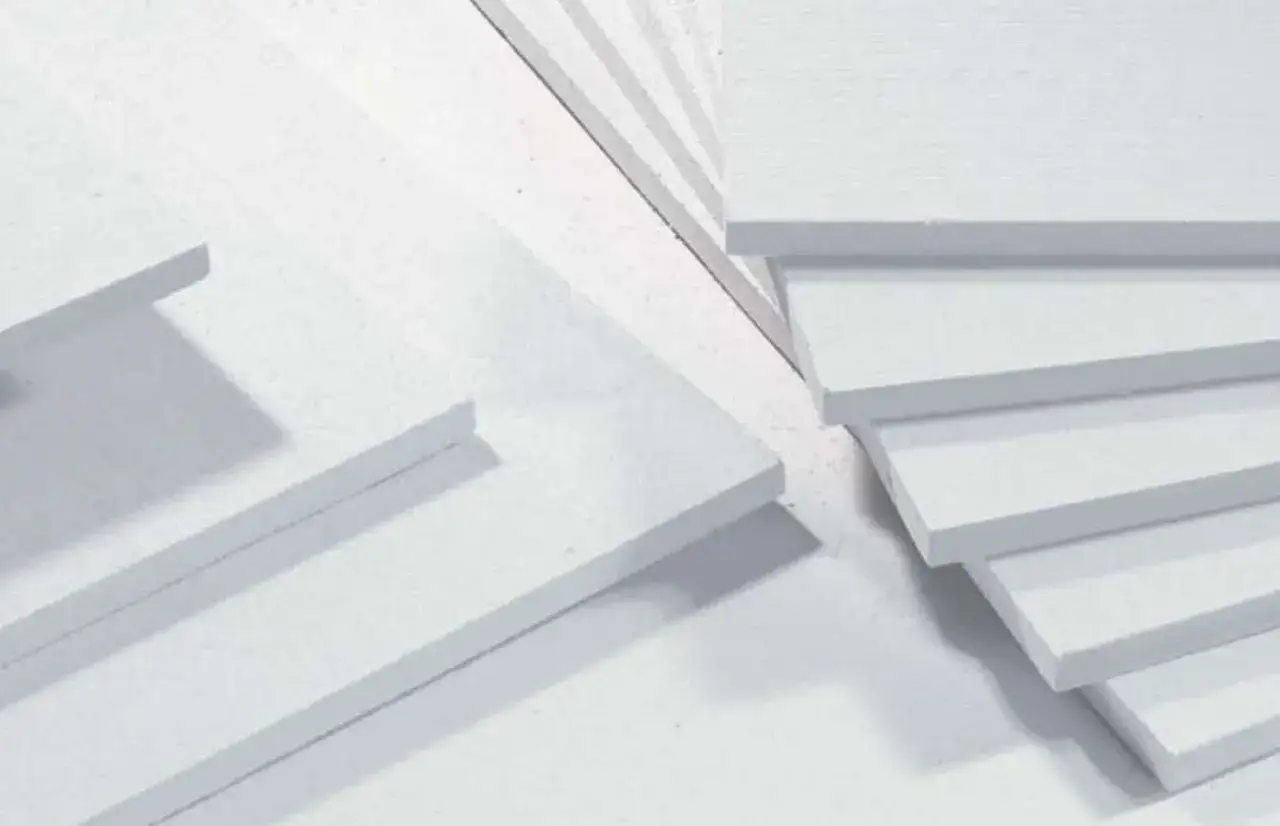 Lastre bianche di fibrogesso impilate, materiale da costruzione versatile.
