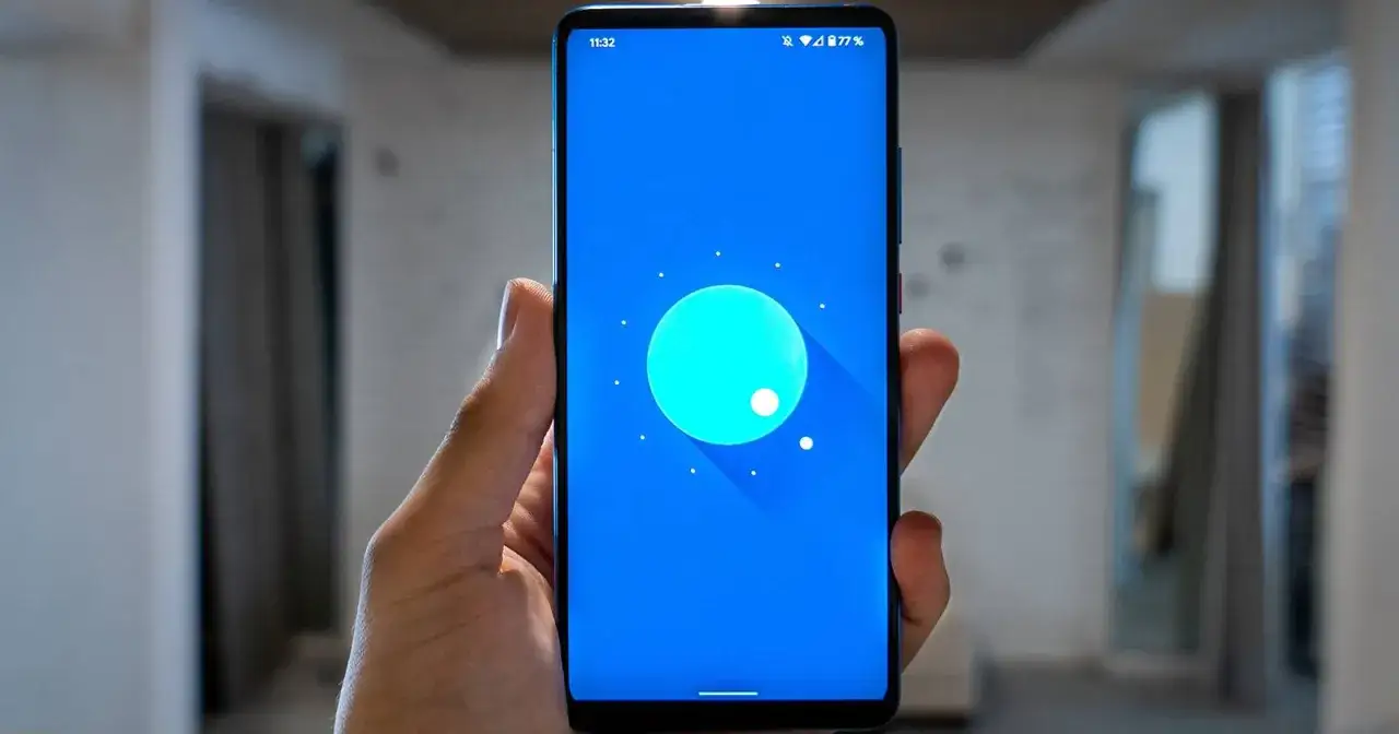 Dłoń trzyma tablet z niebieskim ekranem i ikoną Androida. Poradnik: jak wgrać nowy android do tabletu.