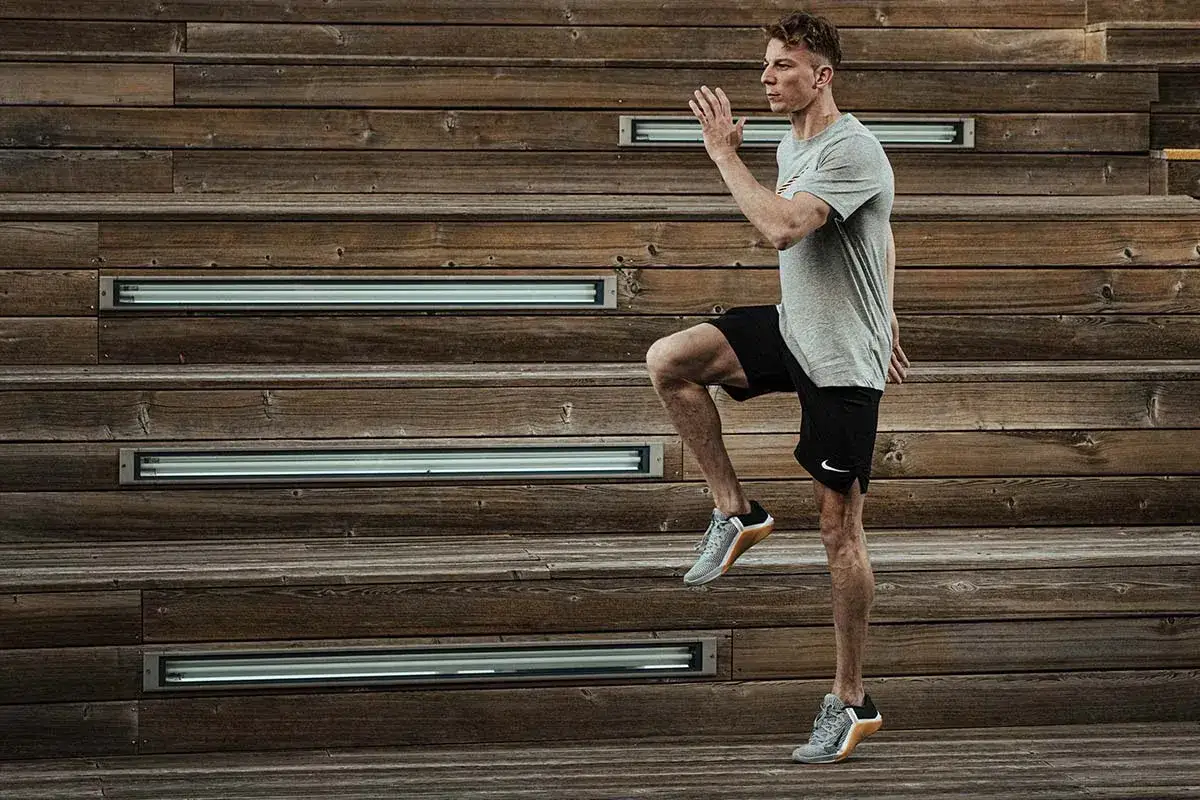 Mężczyzna wykonuje dynamiczne ćwiczenie, które jest częścią treningu HIIT. Co to jest HIIT? To intensywny trening interwałowy.