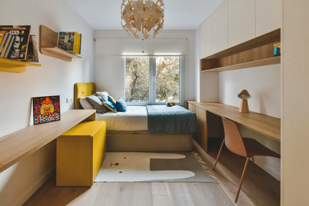 Habitación adolescente chico con cama, escritorio de madera, estanterías y un cuadro de gallo. Alfombra con diseño de oso.