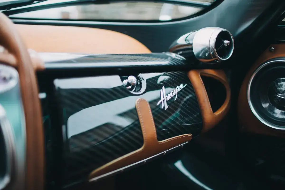 Wnętrze Pagani Huayra: karbonowe detale, skórzane wykończenie i charakterystyczne logo.