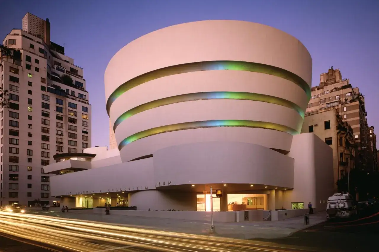El icónico Museo Guggenheim, una de las estructuras diseñadas por Frank Lloyd Wright, con su espiral distintiva y luces de neón.