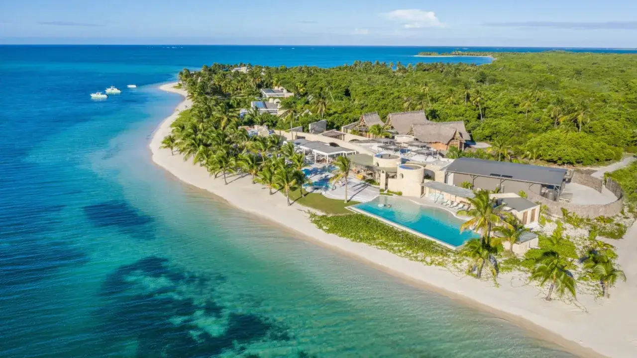 Rajskie wakacje na Madagaskarze: luksusowy resort z basenem przy plaży, otoczony palmami. Idealne miejsce na relaks.