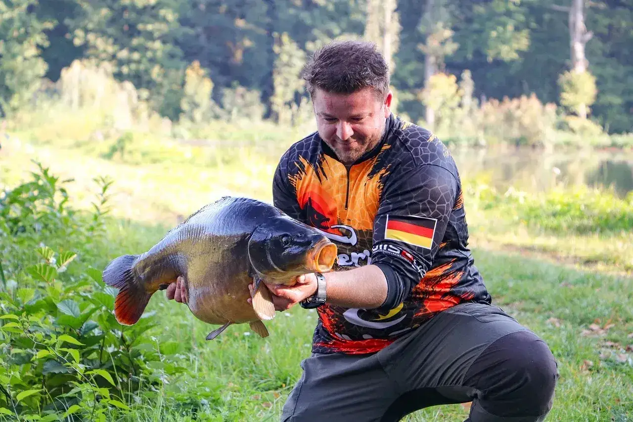 Szczęśliwy wędkarz z Grzegorzewic trzyma w rękach okazałe ryby.