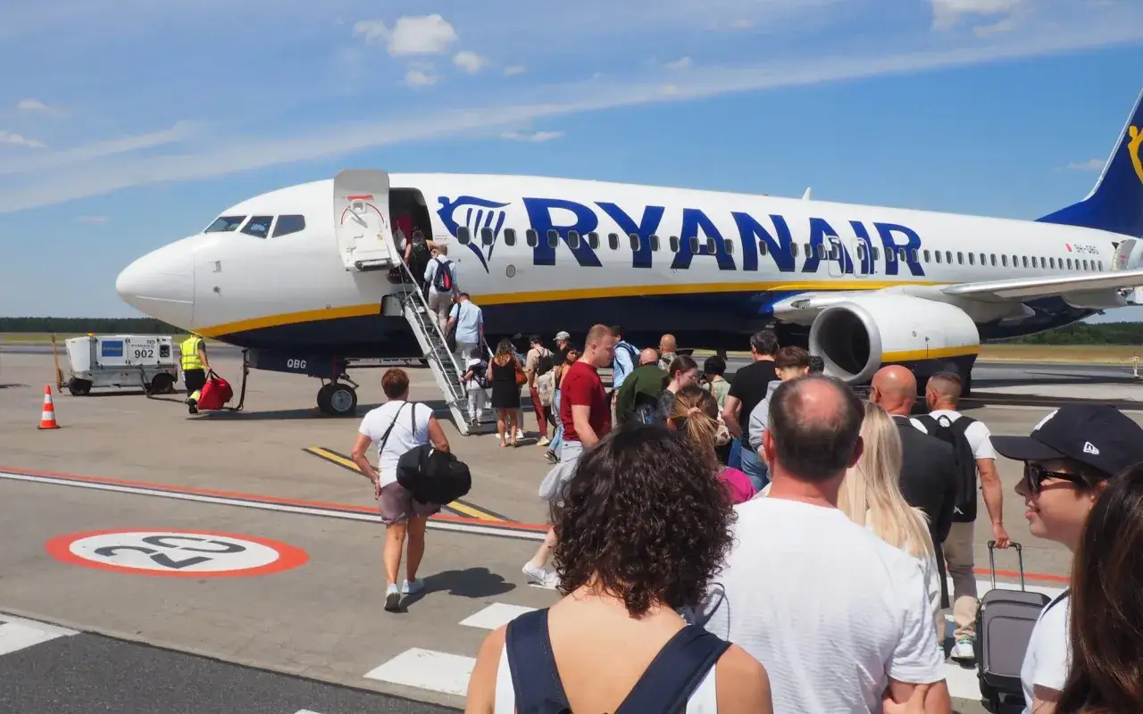 Pasażerowie wsiadają do samolotu Ryanair. Zastanawiasz się, ile alkoholu można przewieźć samolotem Ryanair? Sprawdź przepisy przed podróżą.