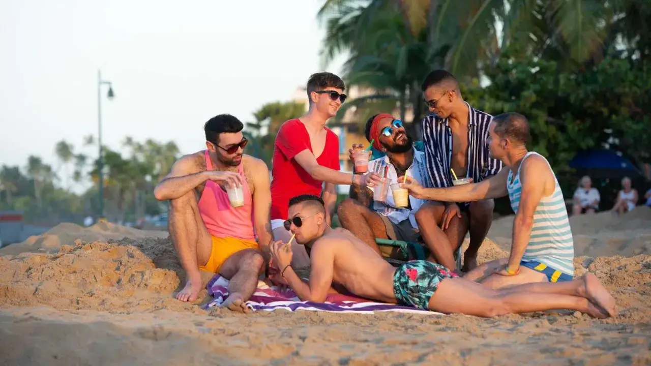 Friends enjoying drinks on the beach, a perfect scene at a San Juan gay resort.