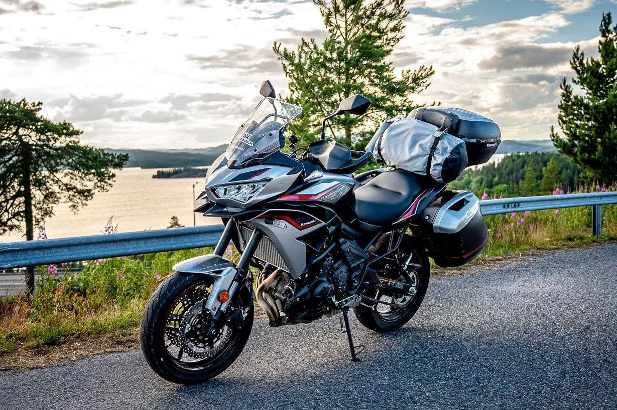 Kawasaki Versys 650 dane techniczne: motocykl turystyczny z kuframi i bagażem, gotowy na przygodę nad jeziorem.