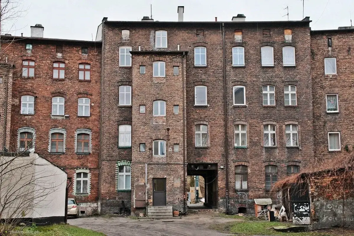 Stare familoki, gdzie każda cegła opowiada historię. Widać tu okna, które widziały pokolenia mieszkańców, jakby doktórka od familoków badała ich stan.