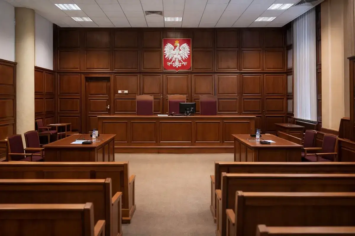 Pusta sala sądowa z orłem na ścianie. Czy tu zapadnie wyrok o niegodności dziedziczenia?