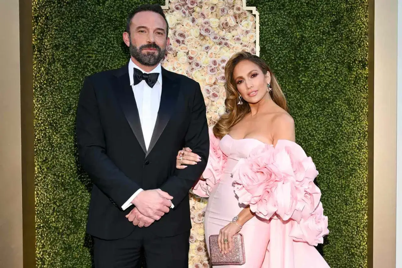 Jennifer Lopez i jej mąż Ben Affleck na czerwonym dywanie. Ona w różowej sukni, on w czarnym smokingu.