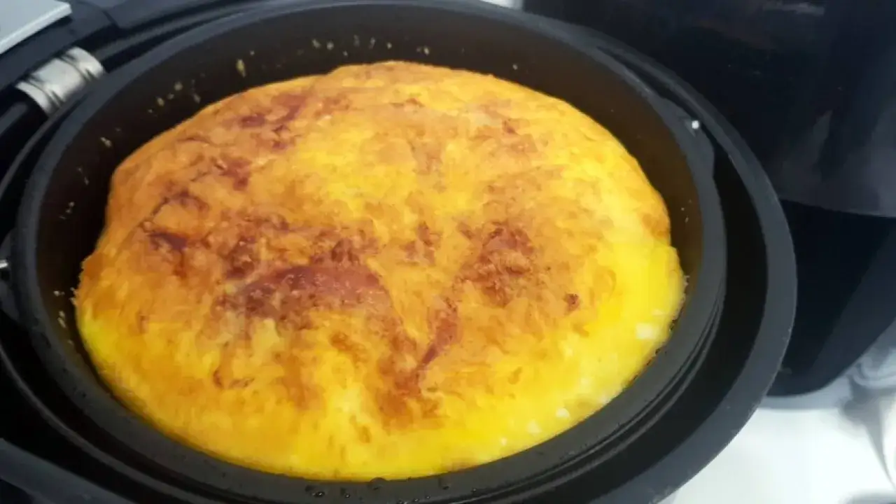 Frittata dorata e soffice appena sfornata nella friggitrice ad aria, pronta per essere gustata.